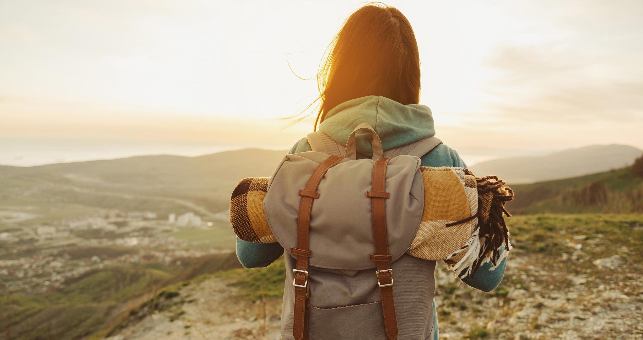 Frau-mit-Rucksack-vor-dem-sonnenuntergang